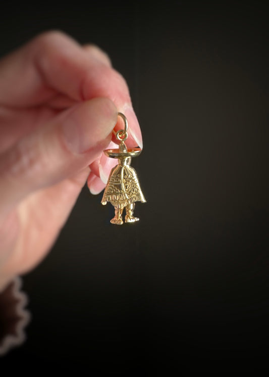 Estate 14kt yellow gold charm in the 3D shape of a man in a sobrero held by a hand against a dark background